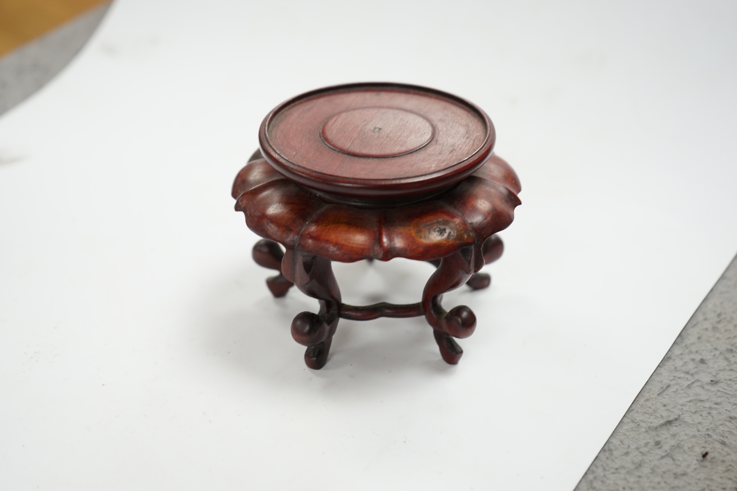 A pair of Japanese Hirado style white glazed porcelain Shishi lion-dog seals and a wooden stand, 10.5cm high. Condition - slight manufacturing glazing losses to base edges